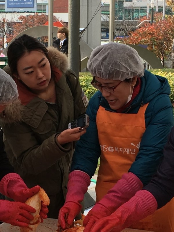 소금에 절인 배추에 양념장을 버무리고 있는 모습입니다.