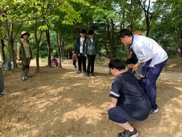 전통놀이인 비석치기를 함께 해보는 사진