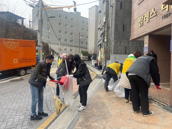 쓸어담은 낙엽을 쓰레기봉투에 담는 직원들