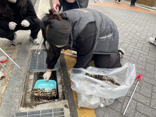 수로에 낙엽이 가득 차 수로를 열고 낙엽을 치우고 있는 직원