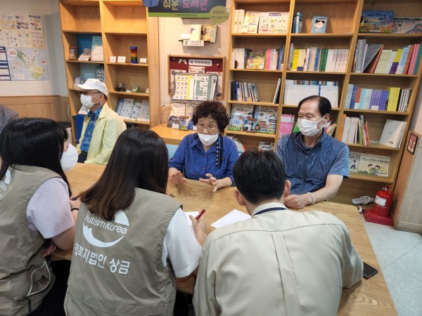 서금요법 자원봉사자의 이야기를 들으며, 이를 마주보고 앉은 실습생들이 기록하는 사진