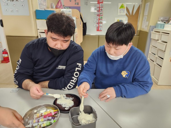 완성된 케이크에 생크림을 바르는 모습