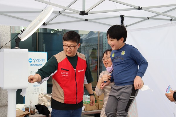 네컷사진 부스에서 아이   눈높이에 맞게 안고 사진 찍는 모습