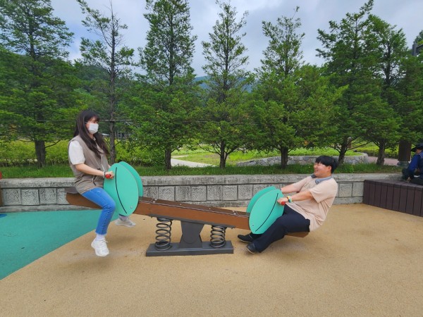 공원에 있는 시소를 타며 즐거워하는 이용자