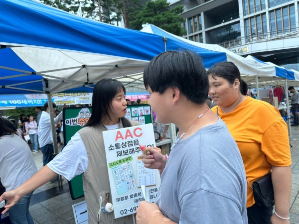 바자회에 방문하여 AAC 설명을 듣고 있는 이용자