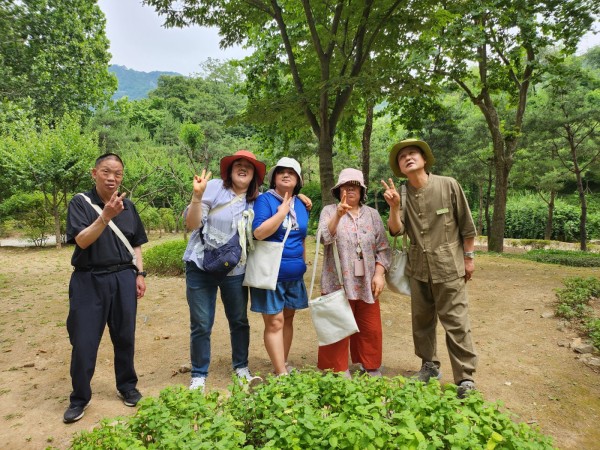 초록초록한 풀 앞에서 단체사진 찍는 사진