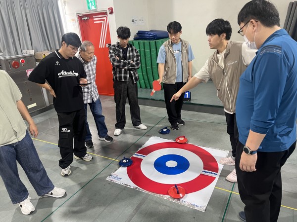 담당자가 타겟을 보며 점수계산하는 방법에 대해 설명하고 있는 모습