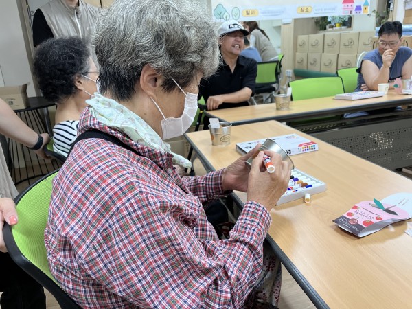 토마토 그림을 보며 따라 그리고 있는 이용인의 모습