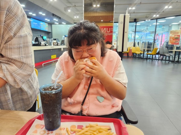 맛있게 햄버거를 먹는 모습