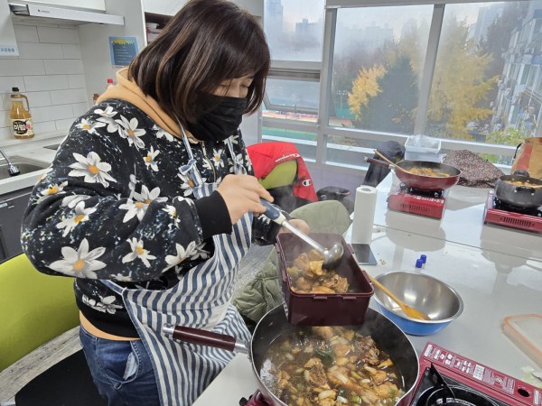 집에서 가지온 반찬통에 찜닭을 옮겨 담는 모습