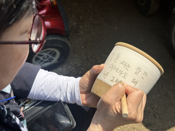 옹기에 글을 작성하고 있는 모습