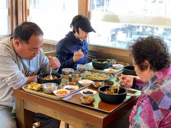 비빔밥과 파전을 맛있게 먹고 있는 모습