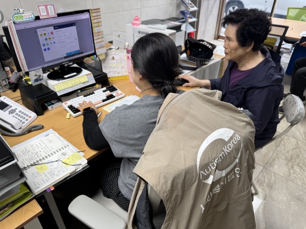 담당자와 활동지원사가 함께 결격사유를 조회하고 있는 사진