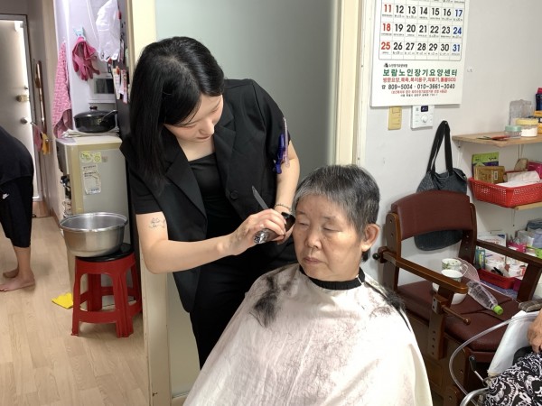 가정 방문하여 열심히 미용 진행하는 모습