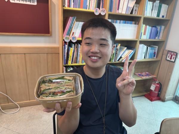 샌드위치를 들고 환하게 웃는 모습