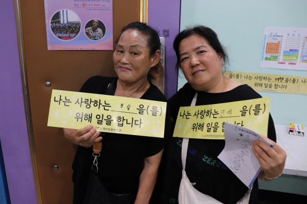 이용인과 활동지원사가 종이슬로건에 서로의 이름을 적은 모습