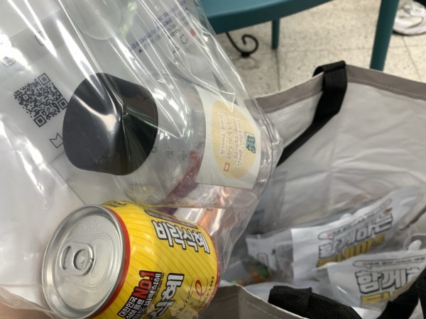 물품바구니에 부채,음료,물병과 홍보포스터가 들어있는 모습