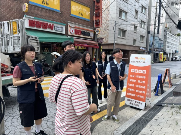 반가운가게 앞에서 경사로, 도움벨, AAC를 소개하는 모니터링단 모습