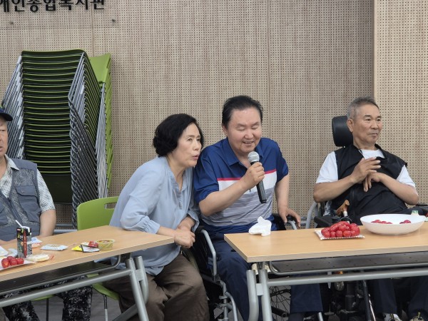 자리에 앉아 신청곡을 부르는 모습