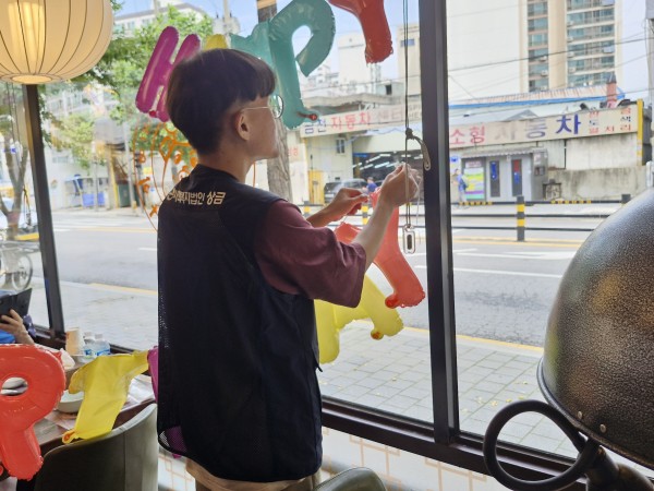 생신 잔치를 위해 풍선을 달고 있는 실습생