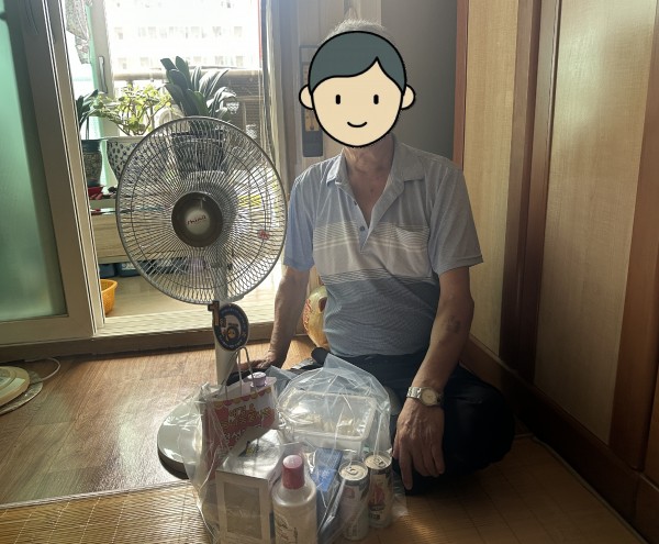 무더위물품으로 선풍기와 여름용품을 받아 환하게 웃고있는 이용인의 모습