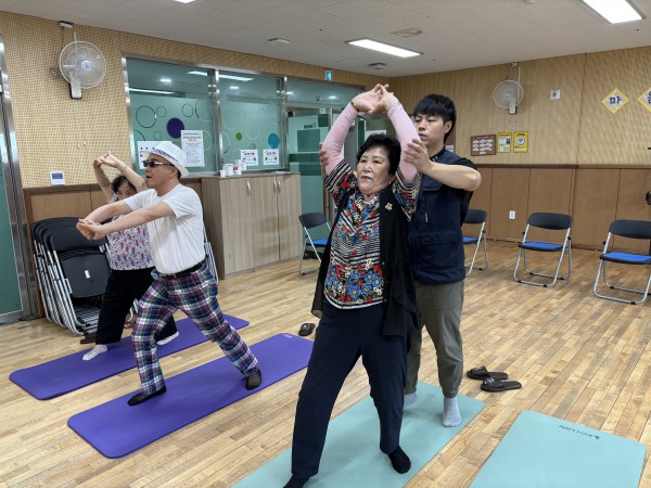 스트레칭중, 팔꿈치를 펴야하지만 펴지못하는 이용인을 지원하는모습