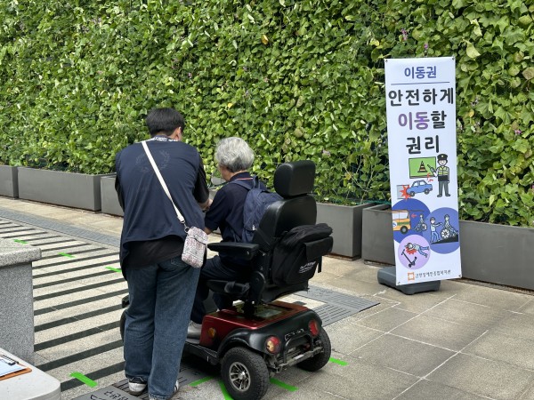 전동스쿠터에 앉아 설명을 듣고 있는 모습