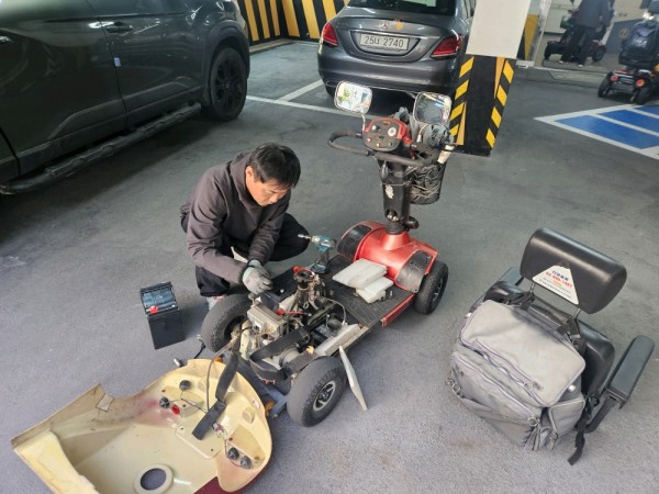 전동보장구에 새로운 배터리를 교체하는 모습