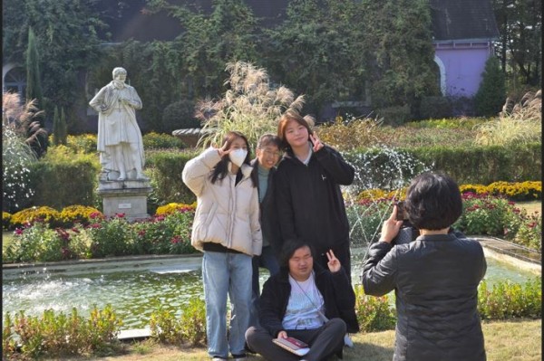 참여자 가족들이 다같이 사진찍는 걸 도와주는 다른 참여자 모습