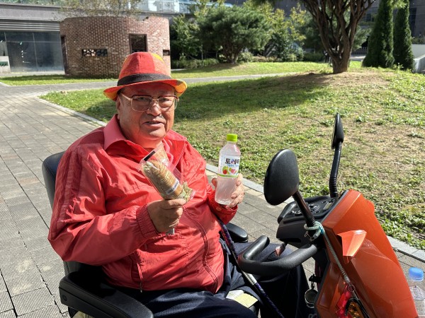 음료를 들고 환하게 웃고 있는 모습