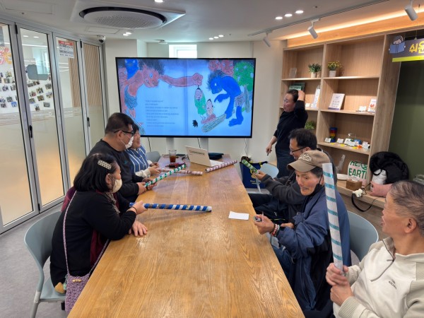 종이 막대기를 이용하여 바닥을 두드리며 스트레스 해소를 하는 모습