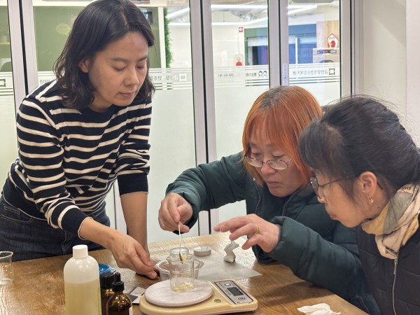 화장품 만드는 실습을 하며 옆에서 보호자 분이 도와주고 있는 모습의 사진