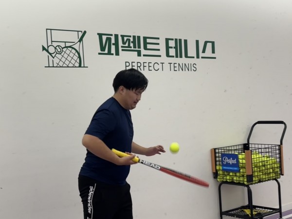 혼자서 테니스공을 사용해서 공을 튕기고 있는 모습의 사진