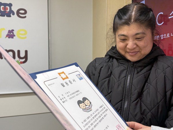 수료증을 바라보며 뿌듯해하는 표정