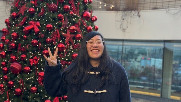 크리스마스트리 앞에서 웃으며 사진찍는 이용인