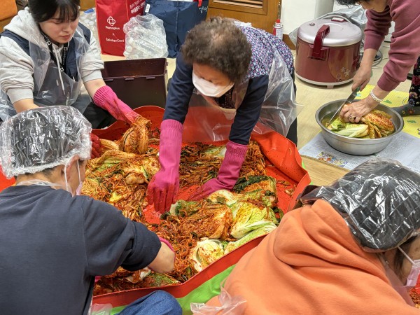 김치 양념 바르는 방법 알려주고 있는 모습