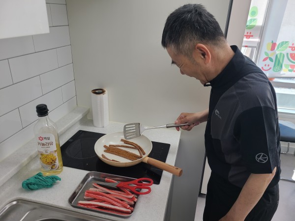 햄과 맛살을 굽고 있는 사랑의 집배원의 모습