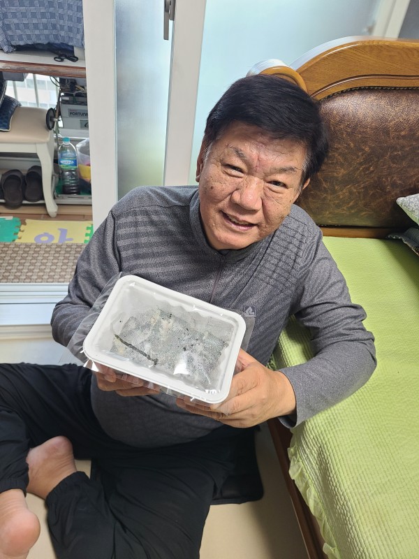 완성된 김밥을 들고 환하게 웃는 사랑의 집배원의 모습