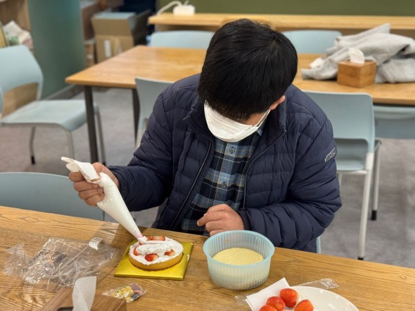 빵과 딸기 위에 크림을 뿌르는 모습