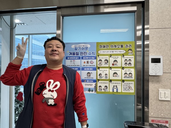 포스터 앞에서 브이하는 이용인의 모습