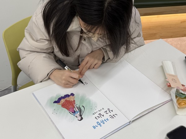 완성된 동화책에 사인하는 모습