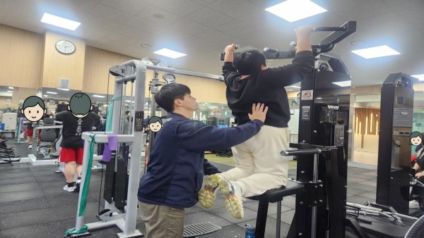 머신도움을받으며 철봉운동하는 모습