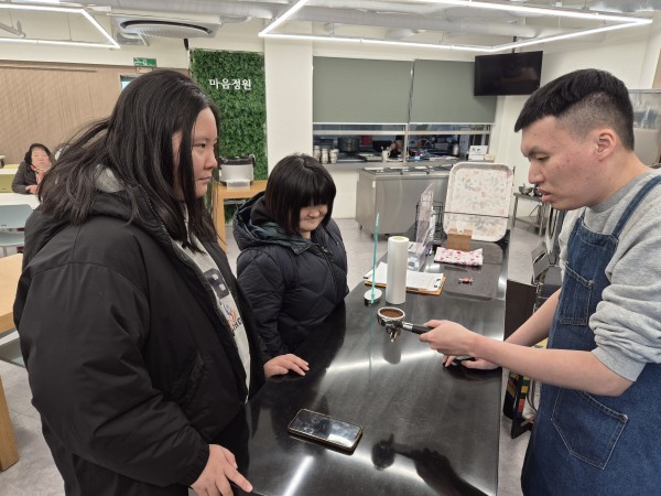 선배바리스타가 원두가루를 템핑한 모습을 설명하는 모습