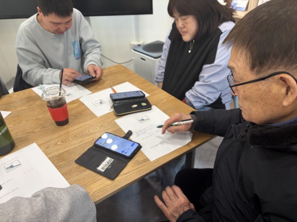 핸드폰으로 디지털 연습하는 참여자들