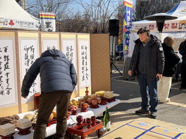 차례상 앞에서 음식을 배치하는 말미마을 주민협의체 모습