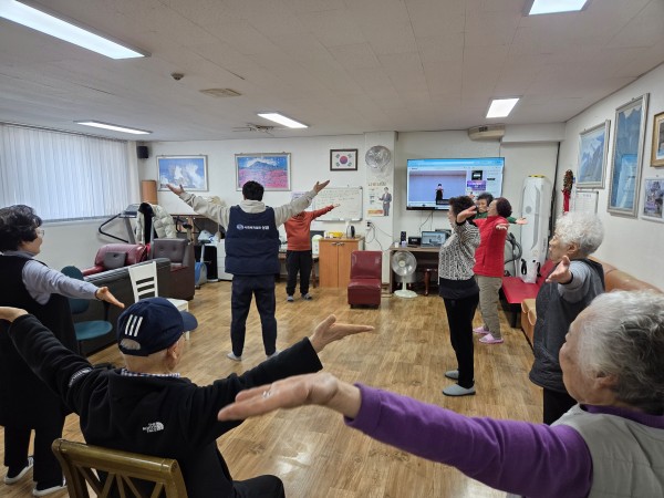 서 있는 상태에서 양팔 벌리기를 하고 있다