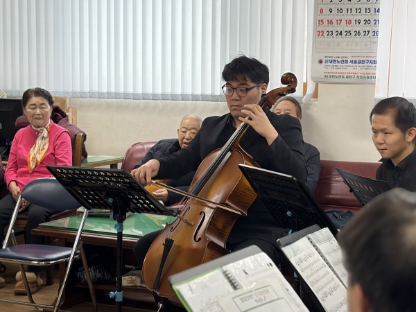 장애인 오케스트라 강사가 악기를 연주하고 있다