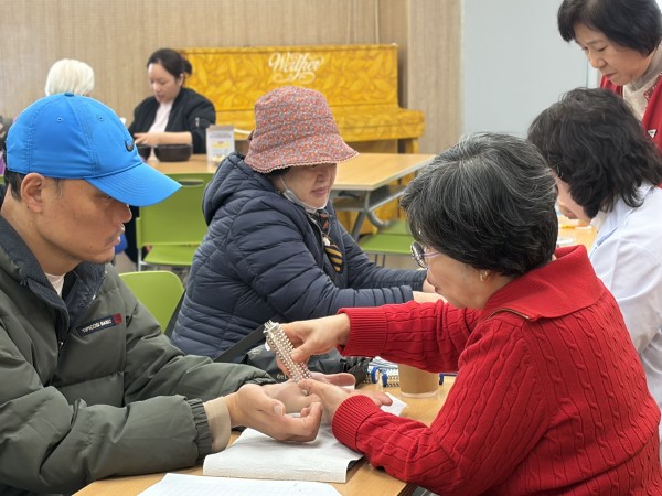 금천손사랑 봉사자가 손지압 진행하는 모습