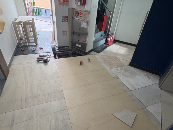 엘레베이터 앞 바닥 공사를 하는 사진