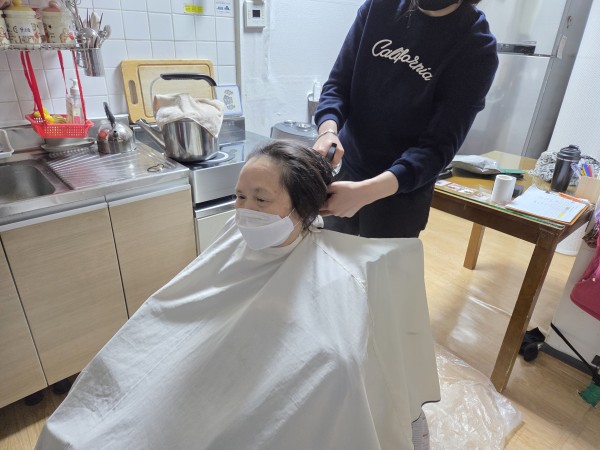미용 선생님에게 이발을 받고 있는 모습